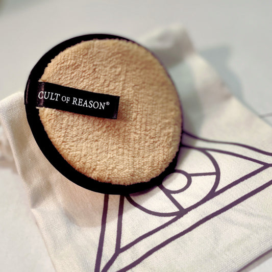 Round, light tan microfiber cleansing pad with Cult of Reason logo on a black tag